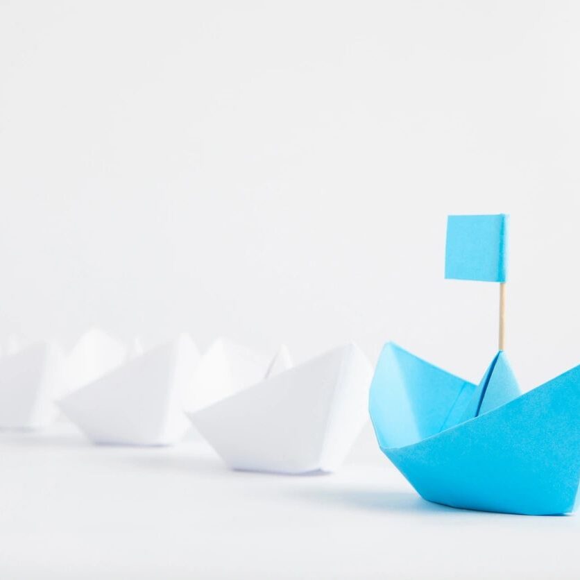 A blue paper boat with a flag on it